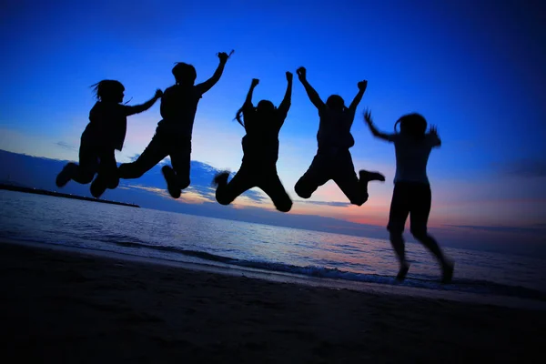 Young friends jumping on the beach — Stock Photo, Image