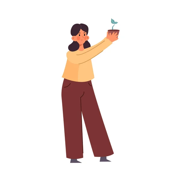 Симпатична дівчина стоїть з горщиком рослини маленького будинку в руках. Векторна ілюстрація в стилі плоского мультфільму . — стоковий вектор