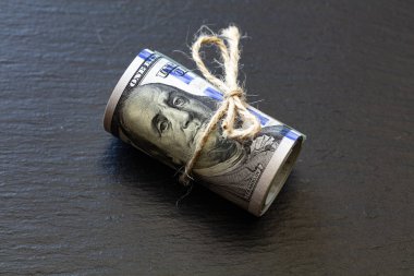 Kaydırma tepsisinde 100 dolarlık banknotların rulosu