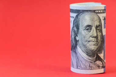 Kırmızı arkaplanda 100 dolarlık banknotlar