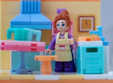 Mutfakta önlüğü olan oyuncak bir kız. küçük bloklar oluşturucu 