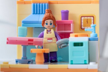 Mutfakta önlüğü olan oyuncak bir kız. küçük bloklar oluşturucu 