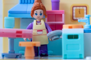 Mutfakta önlüğü olan oyuncak bir kız. küçük bloklar oluşturucu 