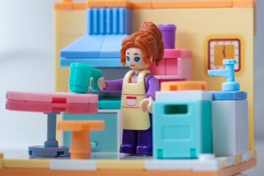 Mutfakta önlüğü olan oyuncak bir kız. küçük bloklar oluşturucu 