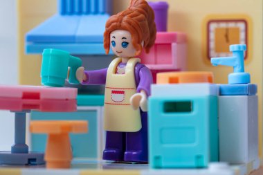 Mutfakta önlüğü olan oyuncak bir kız. küçük bloklar oluşturucu 