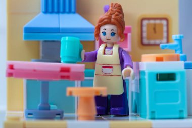 Mutfakta önlüğü olan oyuncak bir kız. küçük bloklar oluşturucu 