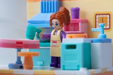 Mutfakta önlüğü olan oyuncak bir kız. küçük bloklar oluşturucu 