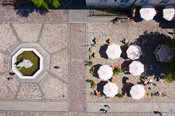 Aerial view on umbrellas in outdoor cafe in Lviv, Ukraine from drone