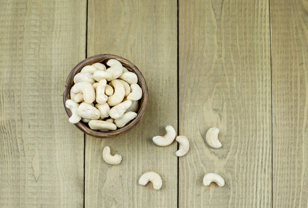 Färska Cashewnötter Papperspåse Träbord Ovanifrån — Stockfoto