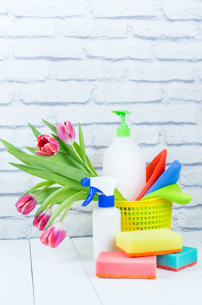 Концепция праздника весенней уборки, принадлежности и инструменты для уборки и весенние цветы. Жидкие дезинфицирующие средства, губки и чистящие средства. Копирование пространства
