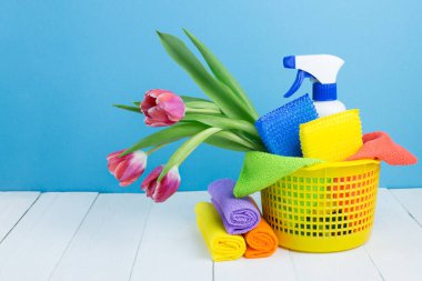 Spring cleaning holiday concept, supplies and tools for cleaning and spring flowers. Liquid disinfectants, sponges and cleaning cloths. Copy space