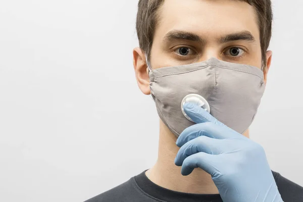 コロナウイルスに対してマスクを身に着けている若いヨーロッパ人男性と親指アップコロナウイルス感染症を予防するために再利用可能な外科用マスクを身に着けている19人 — ストック写真