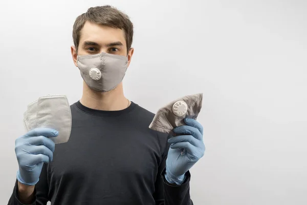 コロナウイルスに対してマスクを身に着けている若いヨーロッパ人男性と親指アップコロナウイルス感染症を予防するために再利用可能な外科用マスクを身に着けている19人 — ストック写真