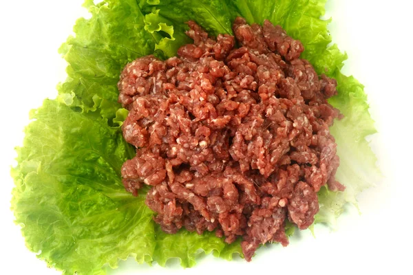 Surowe mięso mielone izolowane na białym tle z zielonymi liśćmi i przyprawami. — Zdjęcie stockowe