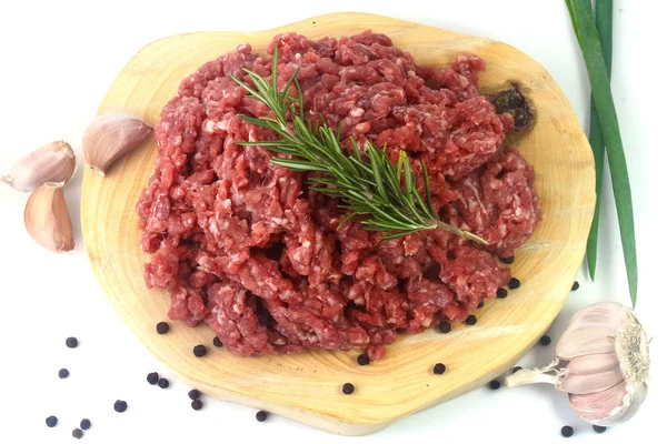 Rauw gehakt vlees geïsoleerd op witte achtergrond met groene bladeren en specerijen. — Stockfoto