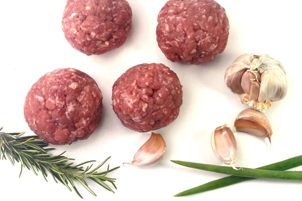 Primo piano carne fresca cruda polpette di manzo isolato su sfondo bianco con foglie verdi — Foto Stock