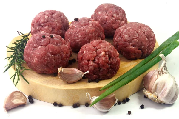 Primo piano fresco carne cruda polpette di manzo isolato su sfondo bianco su tavola di legno rustico — Foto Stock