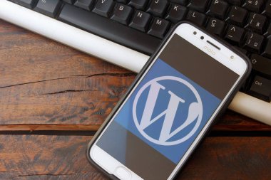 Rio de Janeiro, Brazil - February 14, 2020: WordPress logo on the smartphone screen on the desktop keyboard. It is a system aimed at creating websites and blogs.