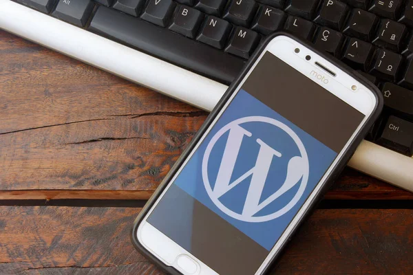 Rio de Janeiro, Brazil - February 14, 2020: WordPress logo on the smartphone screen on the desktop keyboard. It is a system aimed at creating websites and blogs.
