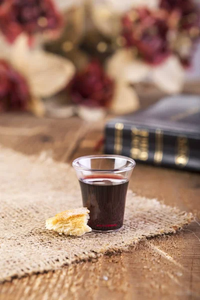 Kommunionempfang. Glas mit Rotwein, Brot und heiliger Bibel. — Stockfoto