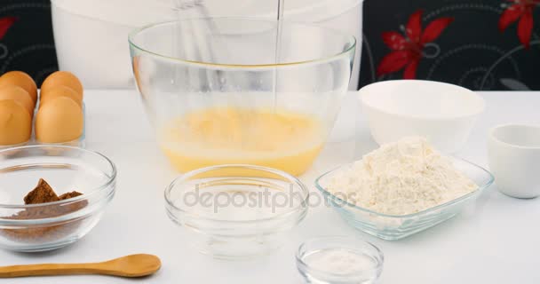 Verter aceite y cacao en un tazón de huevos mezclados para cocinar un pastel — Vídeos de Stock