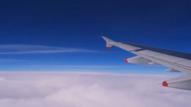 Uçak mavi gökyüzü ve bulutlar üzerinde uçar. Hava yoluyla seyahat. 10000 m-50 C (-58.0 F) dünya üzerinde uçan uçak. Uçak camına toz. 4 k görüntüleri 60 fps.