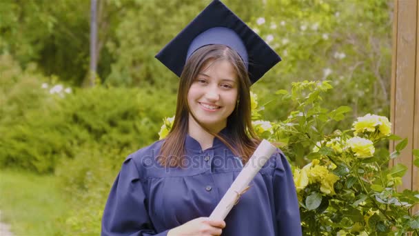 Graduada joven mujer sonriendo a la cámara — Vídeos de Stock