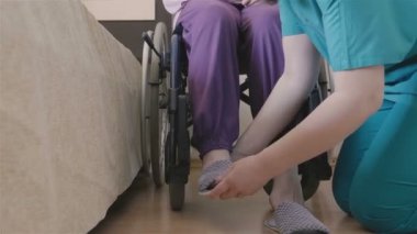 Kadın caregiver üst düzey kadın ayakkabıları koymak için yardım