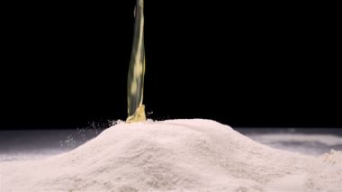 Çiğ yumurta un içinde siyah arka plan üzerine düşen