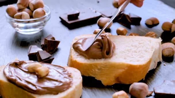 Diffondere crema di cioccolato alla nocciola sul primo piano del pane — Video Stock