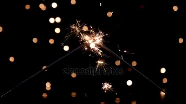 Dois sparklers queimando na frente de luzes ambiente — Vídeo de Stock