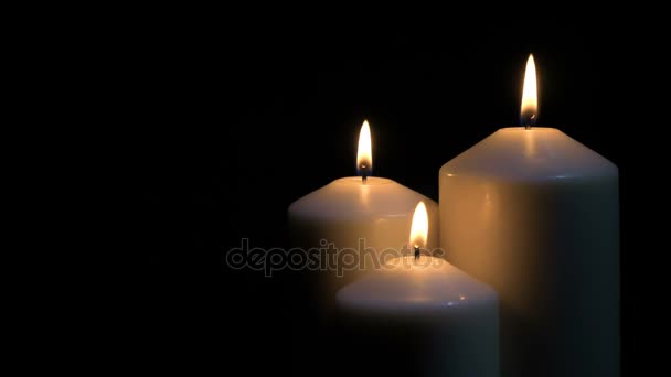 Candles burning on black background