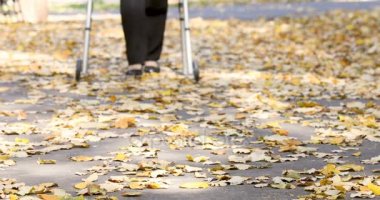Walker sonbahar parkta yürüyen kadın kıdemli bacaklar closeup. Odakta kişi gelir.