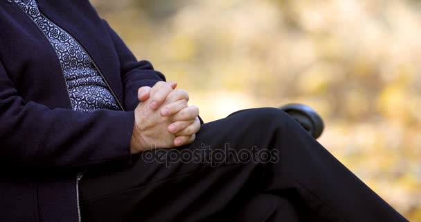 公園屋外のベンチに彼女の手をこすり心配するシニア女性 — ストック動画