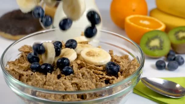 浆果和香蕉水果在谷物片上的慢动作在早餐 健康有机食品 — 图库视频影像