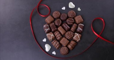 Chocolate pralines heart shaped on black background. Valentines day concept. Loving chocolate and sweets concept. Dolly shot 4k