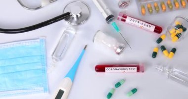 İki kan testi tüpü ve ampullü Coronavirus konsepti şırınga stetoskop termometresi ve haplar. Virüs testi ve tedavi konsepti araştırması. Dolly 4K çekti.