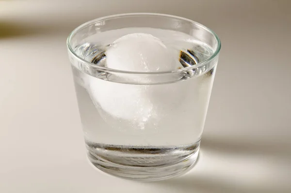 Física. Cubo de hielo flotando sobre el agua . — Foto de Stock