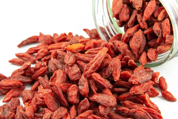 Dried goji berries spilling out of glass jar — Stock Photo, Image