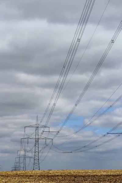 フィールド上の高電圧送電鉄塔 — ストック写真