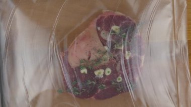Sous vide düşük sıcaklıkta pişirmek için taze baharatlı biftek bacağı. Yakın çekim 4K.