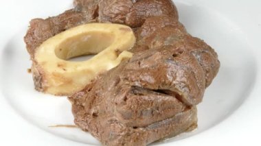 Beyaz bir tabağa pişirilmiş sığır şişi koyarak 4K yakın plan.