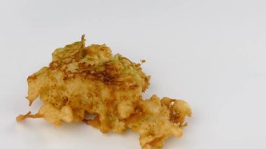 Taze kızartılmış elderflower böreklerini beyaz bir tabağa koyup 4k 'ye yakın tutuyorlar.