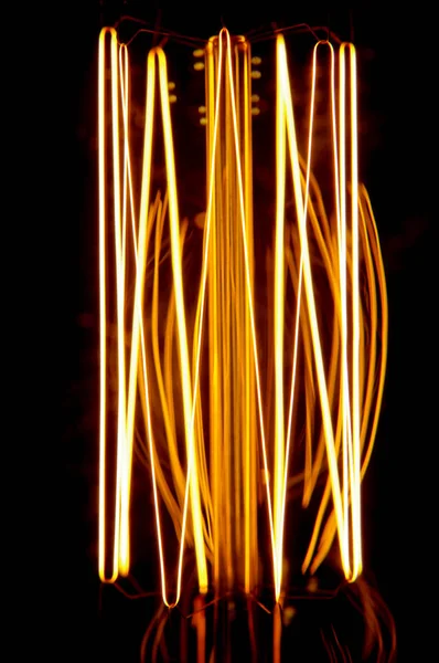 Koyu arka plan üzerinde izole parlayan vintage lamba filaman — Stok fotoğraf