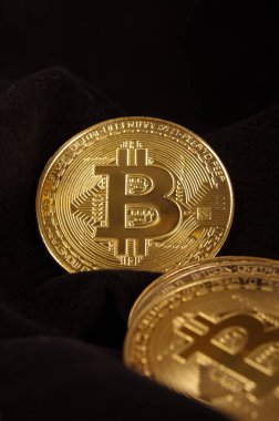 Parlak altın bitcoin sikke üzerinde siyah kumaş