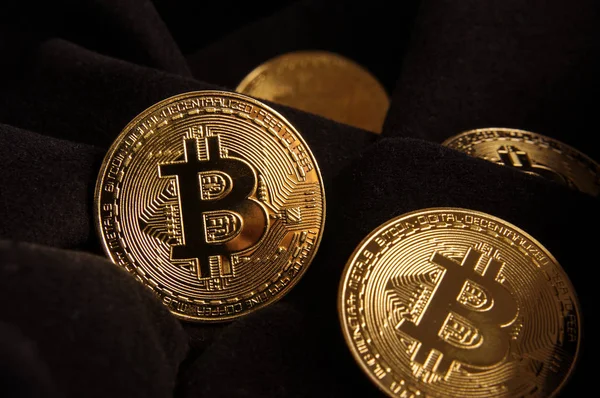 Κοντινό πλάνο των χρυσών νομισμάτων Bitcoin στο μαύρο ύφασμα — Φωτογραφία Αρχείου