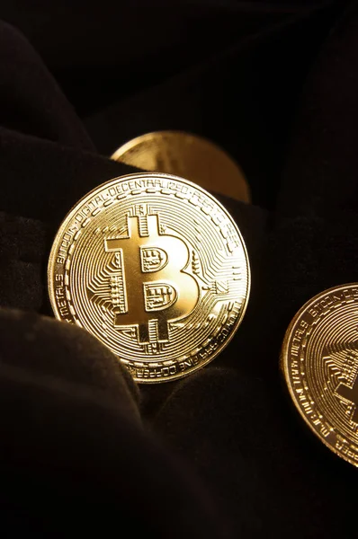 Κοντινό πλάνο των χρυσών νομισμάτων Bitcoin στο μαύρο ύφασμα — Φωτογραφία Αρχείου