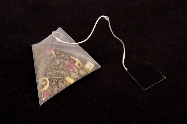 Pyramid shape teabag on the dark background — Stock Photo, Image