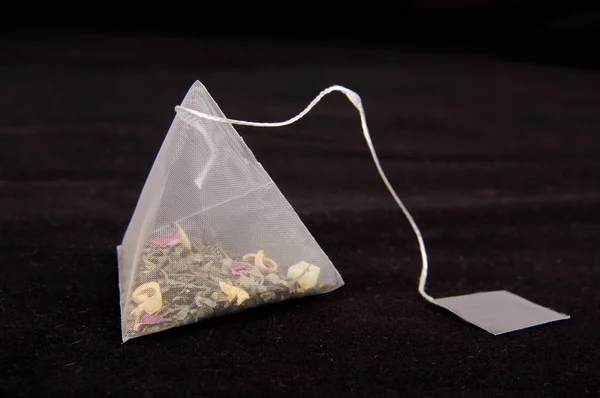 Pyramid shape teabag on the dark background — Stock Photo, Image