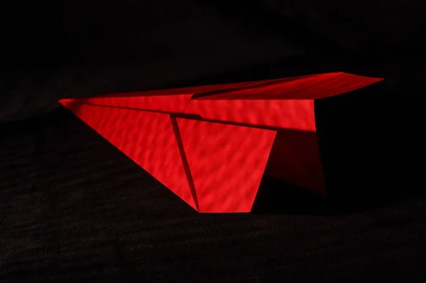 Plano de origami vermelho isolado no fundo preto — Fotografia de Stock